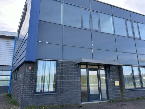 Zakelijk pand aan de Van der Hagenstraat met gevel van donkere bakstenen en grote spiegelende ramen.